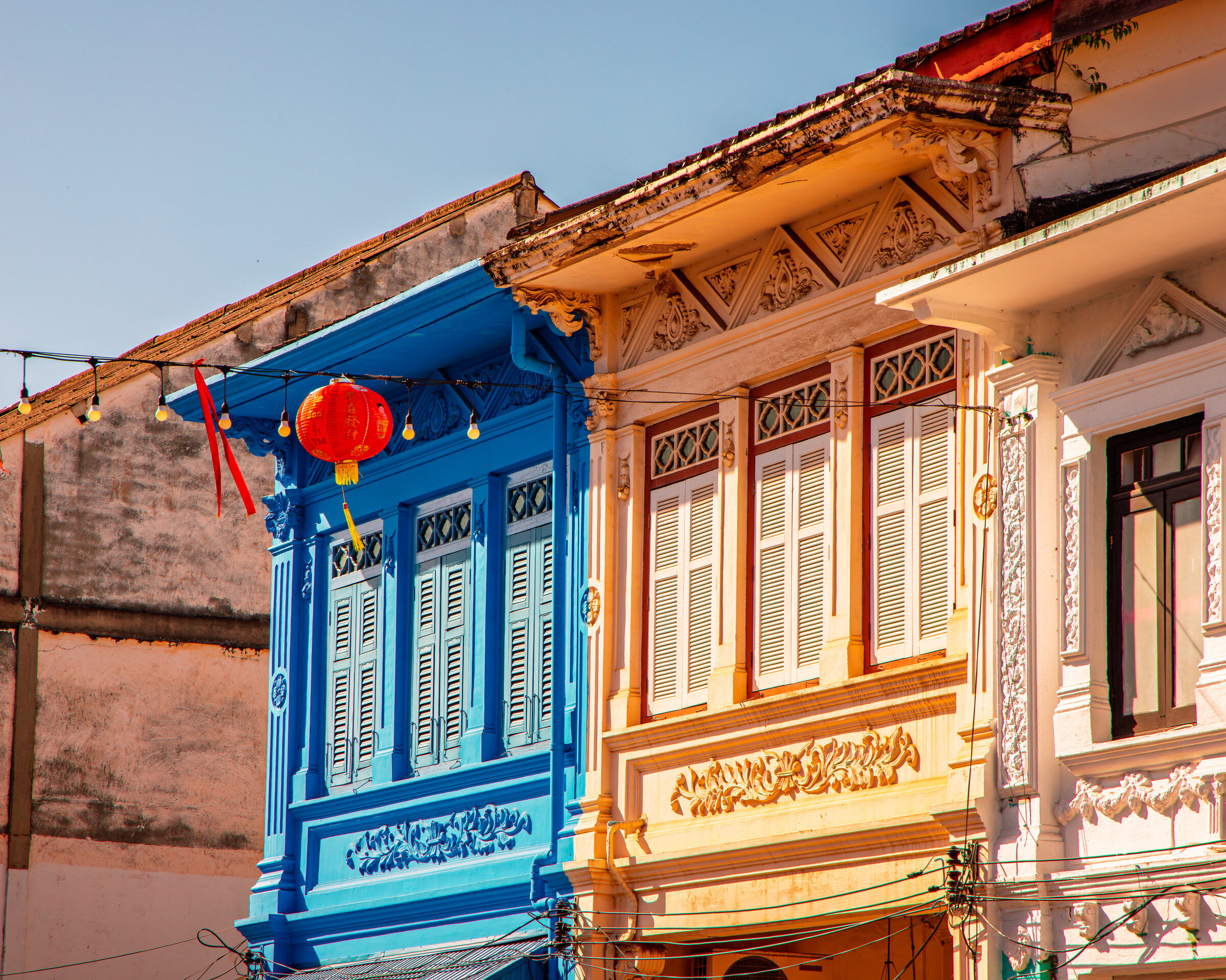 Blue and cream colonial building detail with red lantern