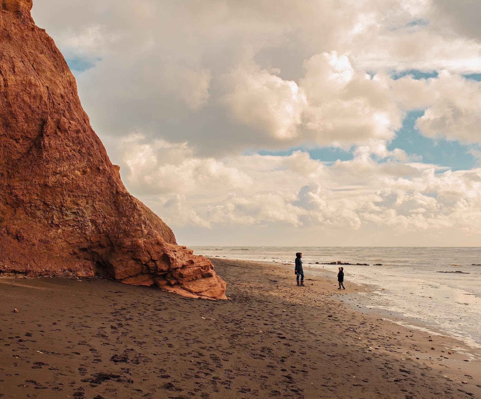 Red cliff beach with figures, Isle of Wight — coastal landscape photography by Samuel John Ford