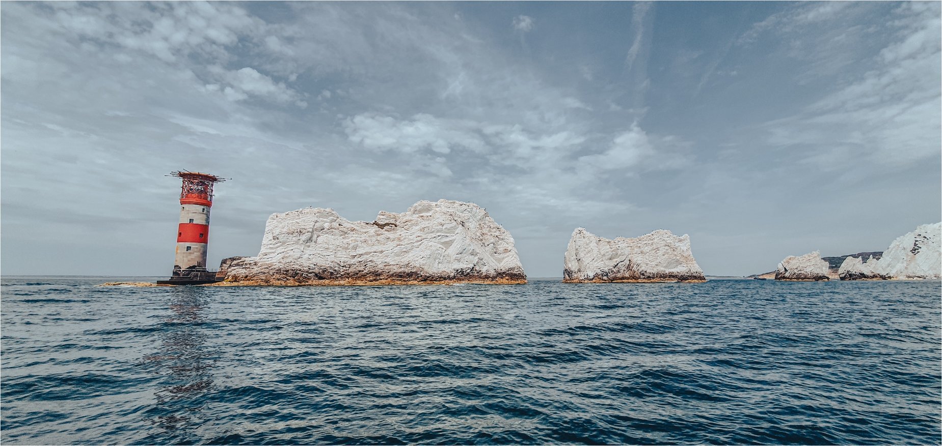 The Needles chalk stacks and lighthouse from sea level, Isle of Wight — landscape photography by Samuel John Ford